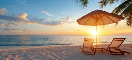 Relaxing beach sunset with lounge chairs and an umbrella by the shore photo