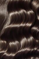 Elegant wavy brunette hair displayed in soft curls and shine under natural light photo