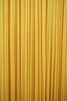 Long strands of yellow pasta displayed against a neutral background for culinary use photo