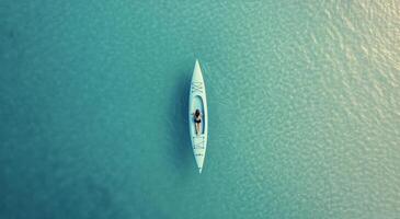 Kayaker exploring clear turquoise waters above vibrant coral reefs in a tropical location photo