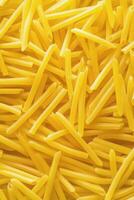 Long strands of yellow pasta displayed against a neutral background for culinary use photo