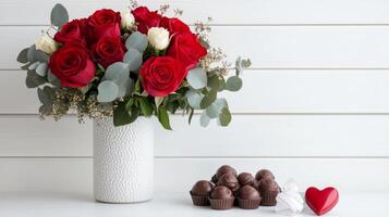 Romantic arrangement with red roses and heart shaped chocolates for special occasions photo
