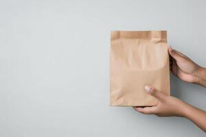 Delivery of a freshly baked pastry in a paper bag by a hand extending towards another hand photo