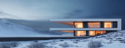 Modern house illuminated at dusk in a snowy landscape with dramatic mountains in the background photo