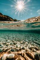 Sunlight dances on pebbles beneath clear water in a tranquil coastal environment photo