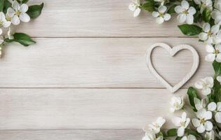 Heart shaped stone surrounded by delicate spring flowers on a wooden surface photo