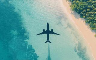 Aerial view of airplane flying over clear turquoise water and sandy beach during sunny day photo