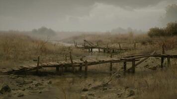 Rusty wooden bridge in a desolate landscape under gray skies video