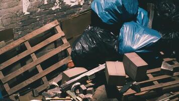 Discarded waste and pallets in a dimly lit storage area during the day video