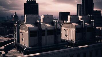 Cooling towers on a city rooftop with a cloudy sky and urban skyline view video