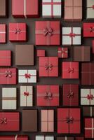 Colorful collection of wrapped gifts arranged on a wall in various shades of red and pink photo