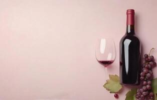 Red wine bottle and glass with grapes on a pastel pink background during a casual gathering photo