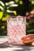 Refreshing grapefruit cocktail garnished with citrus slice in a bright outdoor setting photo