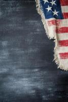American flag with frayed edges draped against a dark textured background photo