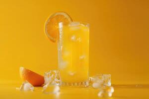 A Glass of Orange Juice with Ice and Orange Slices on a Yellow Background photo