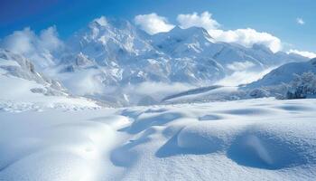 Snowy Mountain Range with Clouds and a Patch of Snow in the Foreground photo