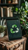 A tablet displaying a recycling symbol surrounded by greenery in a forest setting photo