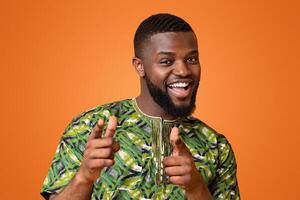 Playful african american guy indicating to camera over yellow studio background photo
