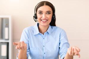 Hotline Customer Support. Cheerful Help Line Operator Girl In Headset Receiving Client's Call Smiling To Camera Sitting In Office. photo
