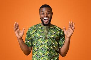 Surprised african man with hands up looking at camera over yellow studio background photo