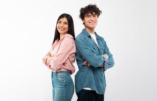 Cheerful Young Couple Crossing Hands In Confident Gesture Smiling To Camera Standing Back To Back Over White Studio Background. Happy Friendship And Love Relationship Concept photo