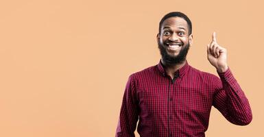 Great Idea Concept. Young Funny African American Man Pointing Finger Up. Excited Black Guy Got Solution To His Problem, Having Aha Moment, Isolated On Yellow Studio Background. Wow, Eureka photo