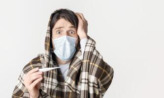 Man in protective mask and with blanket, shocked by high temperature photo