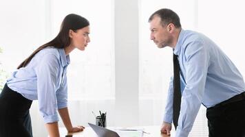 Conflict At Work. Businessman And Businesswoman Staring At Each Other Arguing Having Confrontation Standing In Modern Office. photo