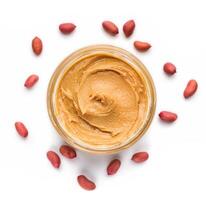 Open jar of peanut butter and scattered peanuts on white background, top view. Unhealthy spread concept photo