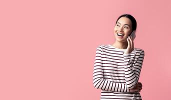 Mobile Call. Cheerful Young Asian Woman Talking On Cellphone, Joyful Excited Koren Lady Having Pleasant Phone Conversation, Enjoying Modern Communication, Standing Over Pink Background, Copy Space photo