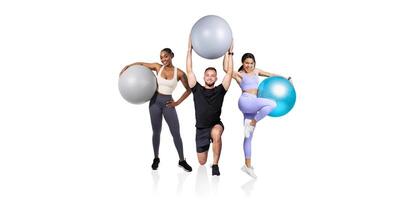 Three individuals showcase their enthusiasm for fitness by posing with colorful exercise balls in a well-lit studio. The group represents teamwork and healthy living. photo