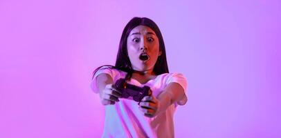 Real game. Surprised young woman with gamepad to play game photo