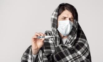 Man in protective mask on quarantine. Self isolation with high temperature photo