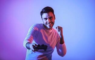 Winning at computer game. Joyful young man with gamepad, free space photo