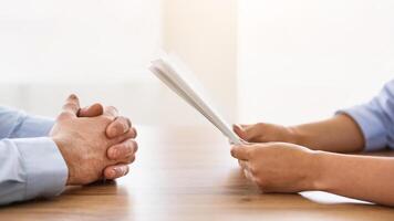 Job Interview Concept. Unrecognizable HR-Manager Talking With Work Applicant Sitting At Desk In Modern Office. Cropped photo