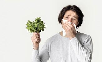 Allergic to product concept. Jaded guy wipes his nose with napkin. photo