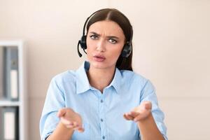 Hotline Service Concept. Call Center Worker Girl Talking With Discontented Customer Consulting And Solving Problem Sitting In Office, Wearing Headset. photo