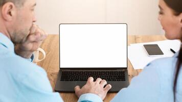 Business Colleagues At Laptop With Empty Screen Working Making Call Sitting In Modern Office. Back View, Mockup photo