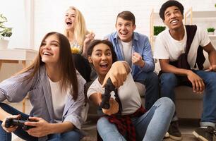 Playful diverse friends playing games online and having fun at home photo
