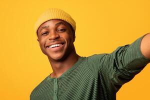 Happy Young Black Guy Taking Selfie While Posing Over Yellow Studio Background, Self-Portrait Of Cheerful Millennial African American Man Having Fun, Looking And Smiling At Camera, Closeup Shot photo