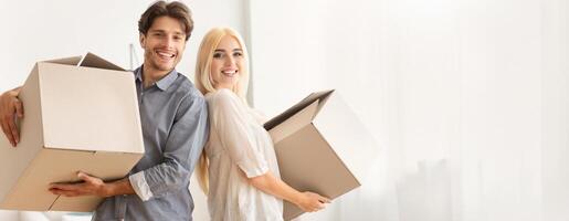 House Ownership And Relocation. Man And Woman Holding Moving Boxes Standing Back-To-Back Indoor, Copy Space photo