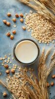 A jar of oat milk surrounded by oats and hazelnuts on a textured surface photo