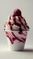 Delicious strawberry ice cream sundae with whipped cream and raspberry sauce served in a cup photo