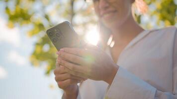 Close-up woman using mobile phone outdoors browsing social network checking email sending electronic sms message on smartphone making order in online shop booking in Internet cellphone new application photo