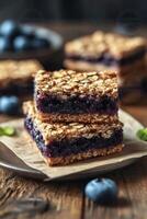 Blueberry oat bars on a wooden table with fresh blueberries and mint leaves photo