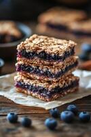 Blueberry oat bars on a wooden table with fresh blueberries and mint leaves photo