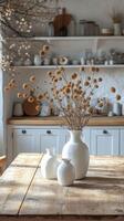 Simple table arrangement with dried flowers in a vase in a bright kitchen setting photo