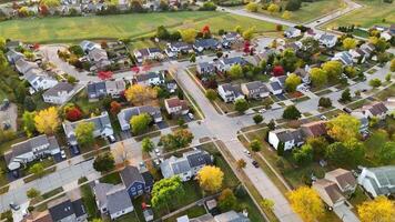 Aerial View of Suburban Neighborhood in Fall. Vibrant aerial view of a suburban neighborhood with colorful autumn trees, neatly arranged houses, and winding streets. video