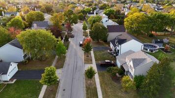 Aerial view of suburban neighborhood with tree-lined streets and houses - A peaceful aerial view showcasing a suburban neighborhood with tree-lined streets, neatly arranged houses, and vibrant video