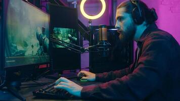 Happy Caucasian gamer addict man guy influencer streamer playing virtual pc game cyber sport at home two monitors computer. Focused male player blogger speak microphone device blog radio stream vlog photo